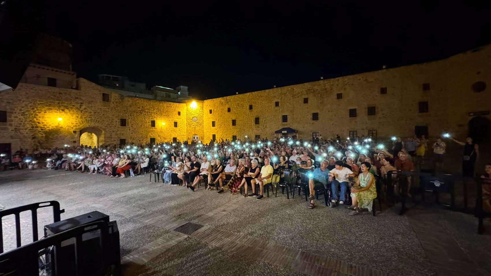 Final de concierto con el público iluminando el patio